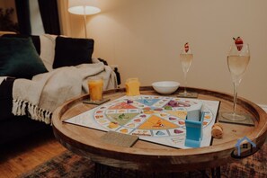A wooden table with a board game, glasses of a clear liquid, and a corkscrew. - Dale House, sleeps 7, central, parking x2, garden (Rothwell)
