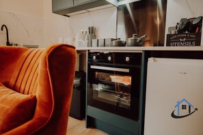Cozinha com design moderno, com forno preto e geladeira branca.