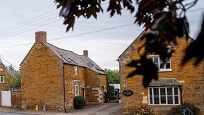 A traditional stone building with a sign indicating 'The Old Plough Inn.'