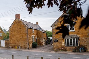 A traditional stone building with a sign indicating 'The Old Plough Inn.' - The Plough, 4 beds, sleeps 9, free parking (Caldecott)