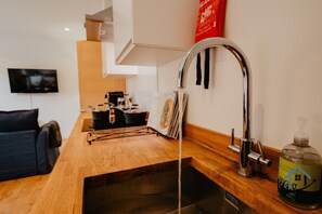 A modern kitchen with a wooden countertop, a stainless steel sink, and a coffee machine. - Flat B, sleeps 4, very central, 2nd Floor Derngate (West Northamptonshire)