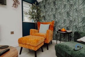 A living room with a sofa, a chair, a small table with fruits, and a plant. - Penthouse - 5 bed 4 bath sleeps 10 parking wi-fi (Desborough)