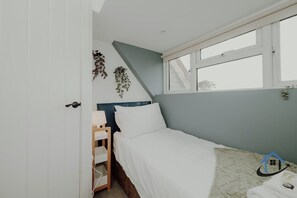 Un dormitorio con una cama, una ventana y una puerta.