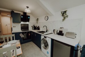 A compact kitchen with a washing machine, a microwave, a sink, and a toaster. - Penthouse - 5 bed 4 bath sleeps 10 parking wi-fi (Desborough)