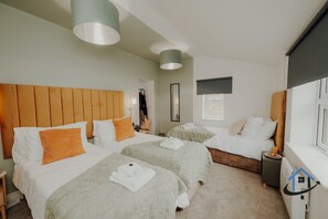 Ein Hotelzimmer mit zwei Betten, einem Holzkopfstück und einem großen Fenster.