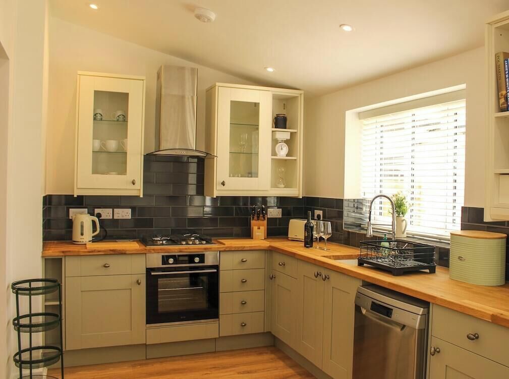 A kitchen with a stove, oven, sink, and cabinets.
