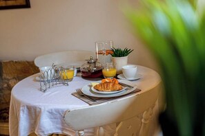 Ein Frühstückstisch mit einem Croissant, Orangensaft und einer Kaffeekanne.