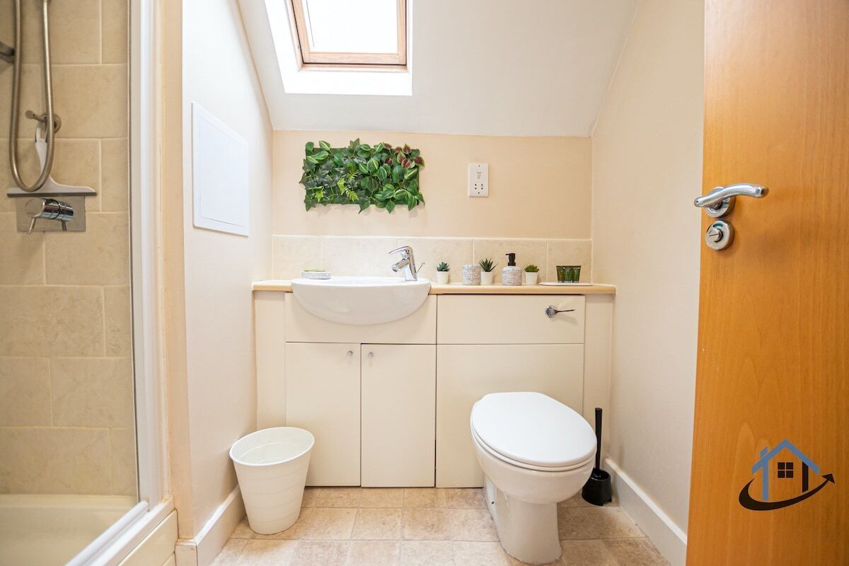 Une petite salle de bain comprenant une douche, des toilettes et un lavabo.
