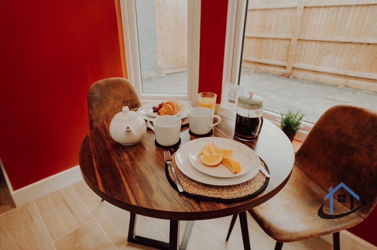 A breakfast setting with a table, chairs, and a window view.