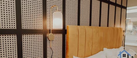 Ein Hotelzimmer mit einem Bett, einer Wand mit einem perforierten Design und einer Nachttischlampe.