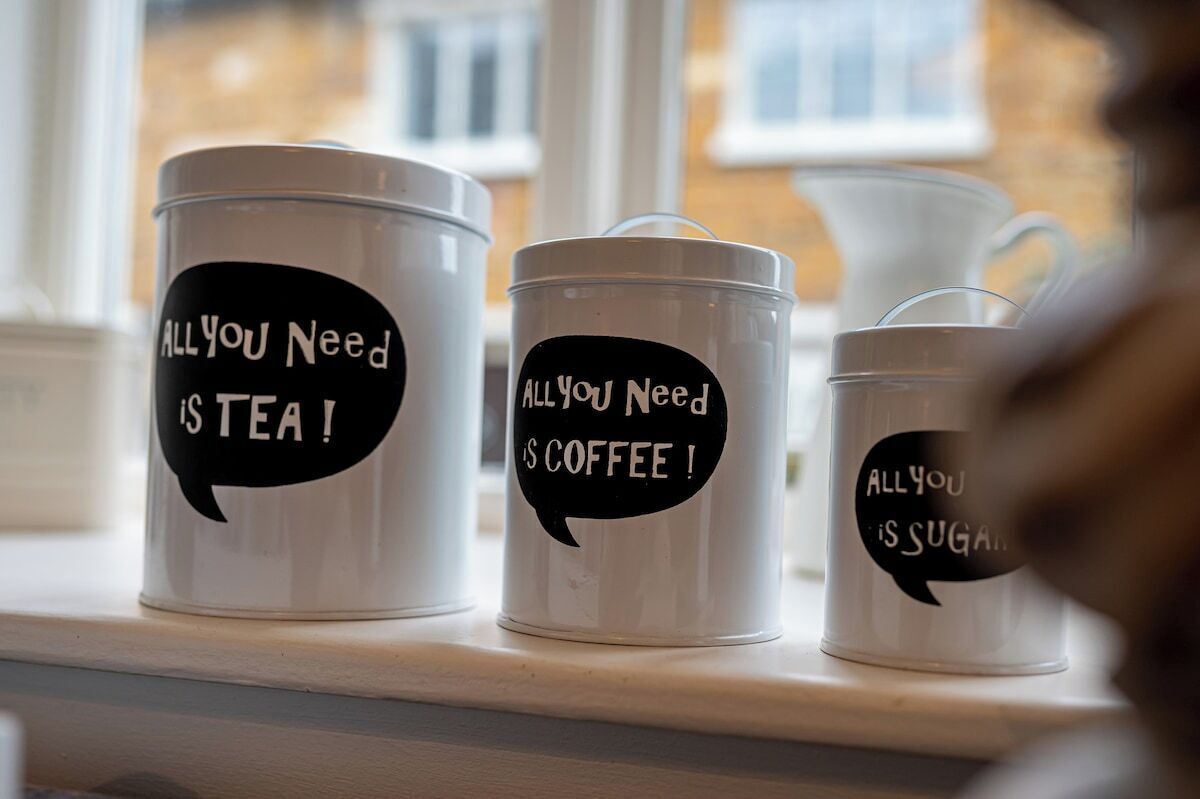 Three white containers with black speech bubbles on a shelf.