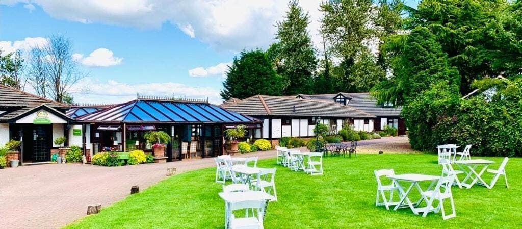 Un hotel con una zona de estar al aire libre techada y un césped bien cuidado.