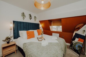 Une chambre moderne avec un grand lit, une table de chevet, un miroir et une fenêtre.