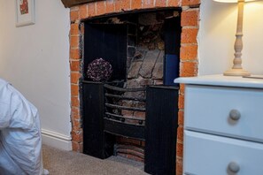A fireplace with a stone surround and a decorative item on the mantel.