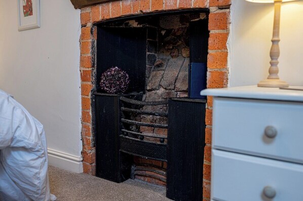 A fireplace with a stone surround and a decorative item on the mantel.