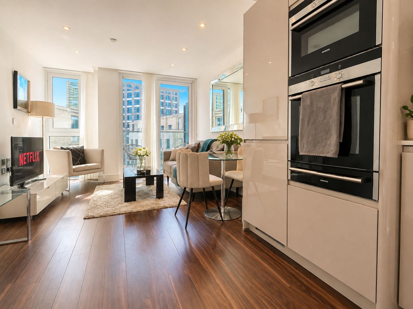 A modern apartment with a kitchen, dining area, and living room.