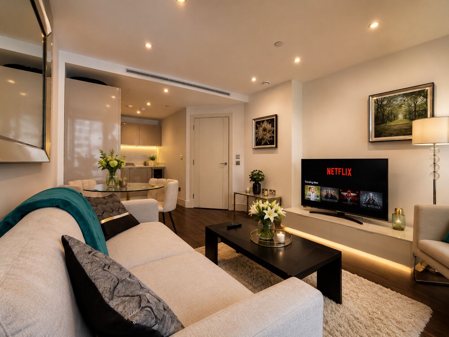 Ein modernes Wohnzimmer mit einer Couch, einem Couchtisch und einem Flachbildfernseher, der Netflix anzeigt.