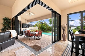 A modern living space with a patio area, a pool, and a view of the outdoors. - Dog-Friendly Canalfront Retreat with Heated Pool & Kayaks (Cape Coral)