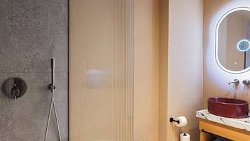 A bathroom with a shower, toilet, and sink with a marble countertop.