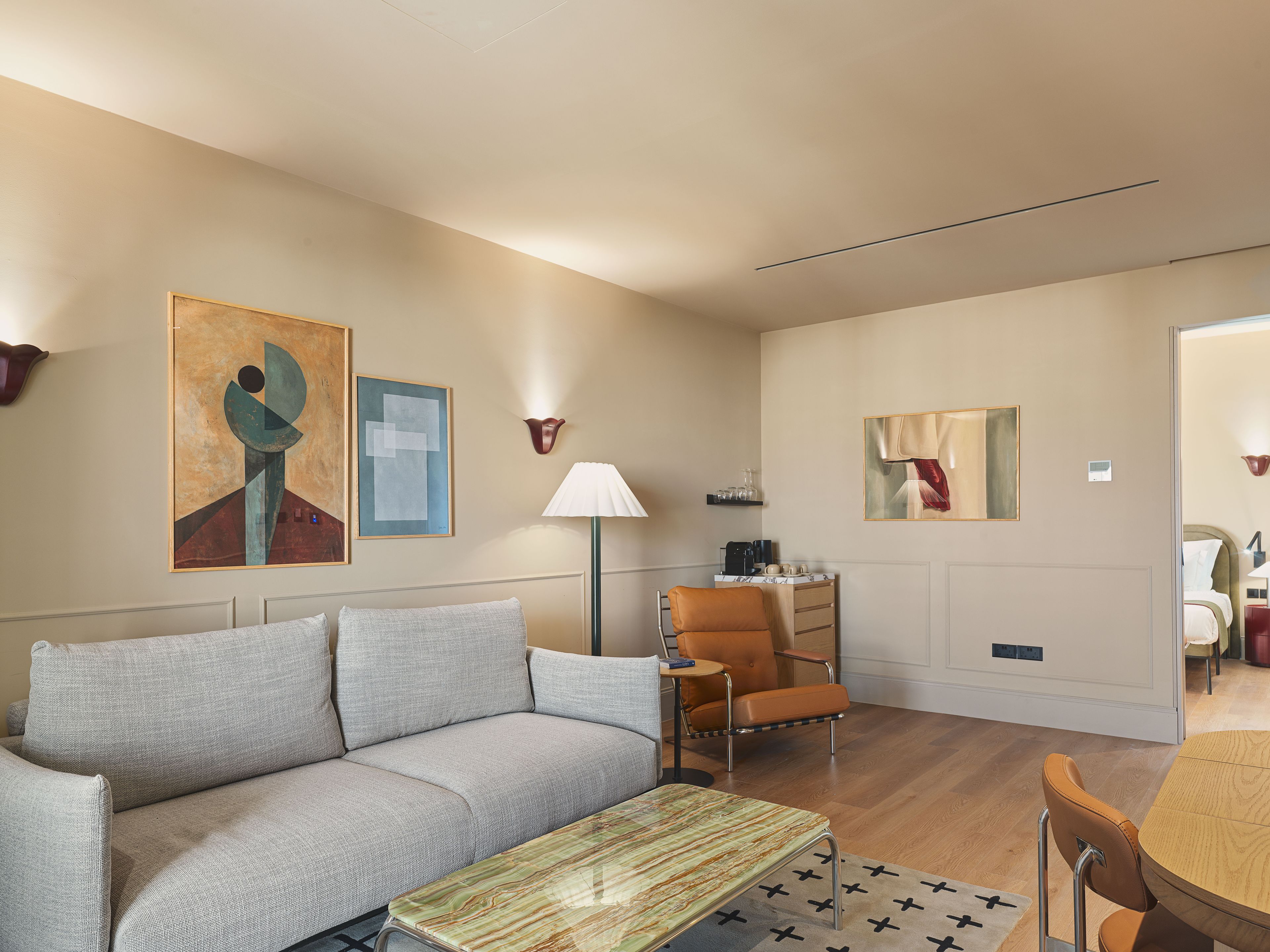 A modern living room with a sofa, a coffee table, and a dining area with a table and chairs.