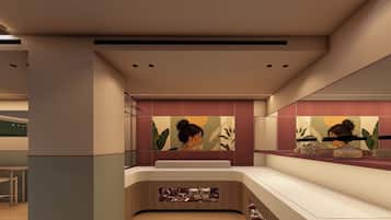Un interior moderno con una mesa de recepción, una zona de estar y una pared decorada con obras de arte.
