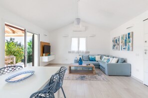 Ein stilvolles Wohnzimmer mit Sofa, Couchtisch und Essbereich.