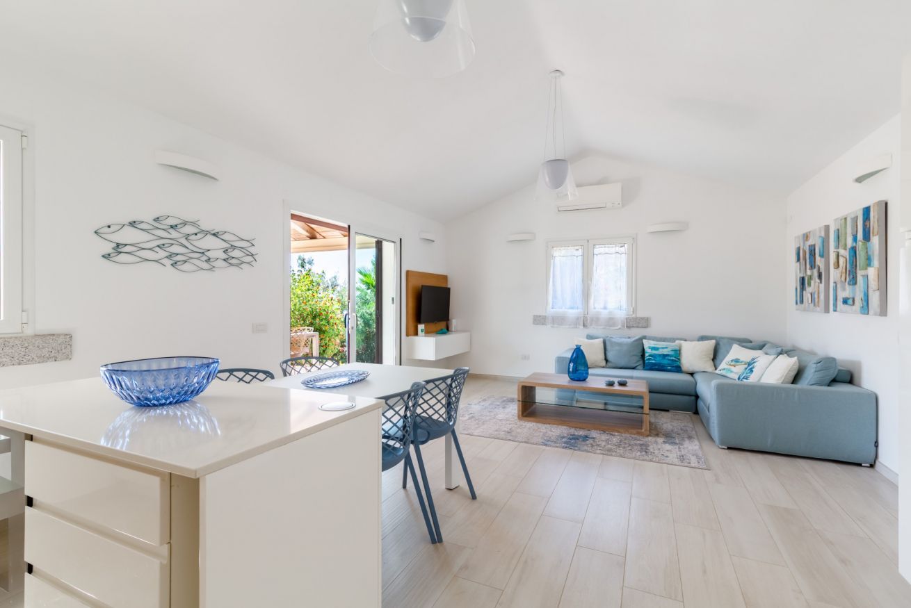 Un espacio habitable moderno con una isla de cocina, un sofá y un comedor.