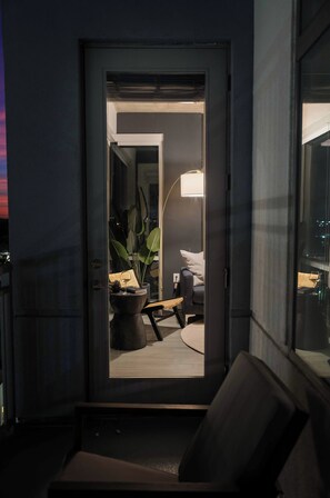 En dörröppning som leder in till ett rum med en säng, en lampa och en växt.