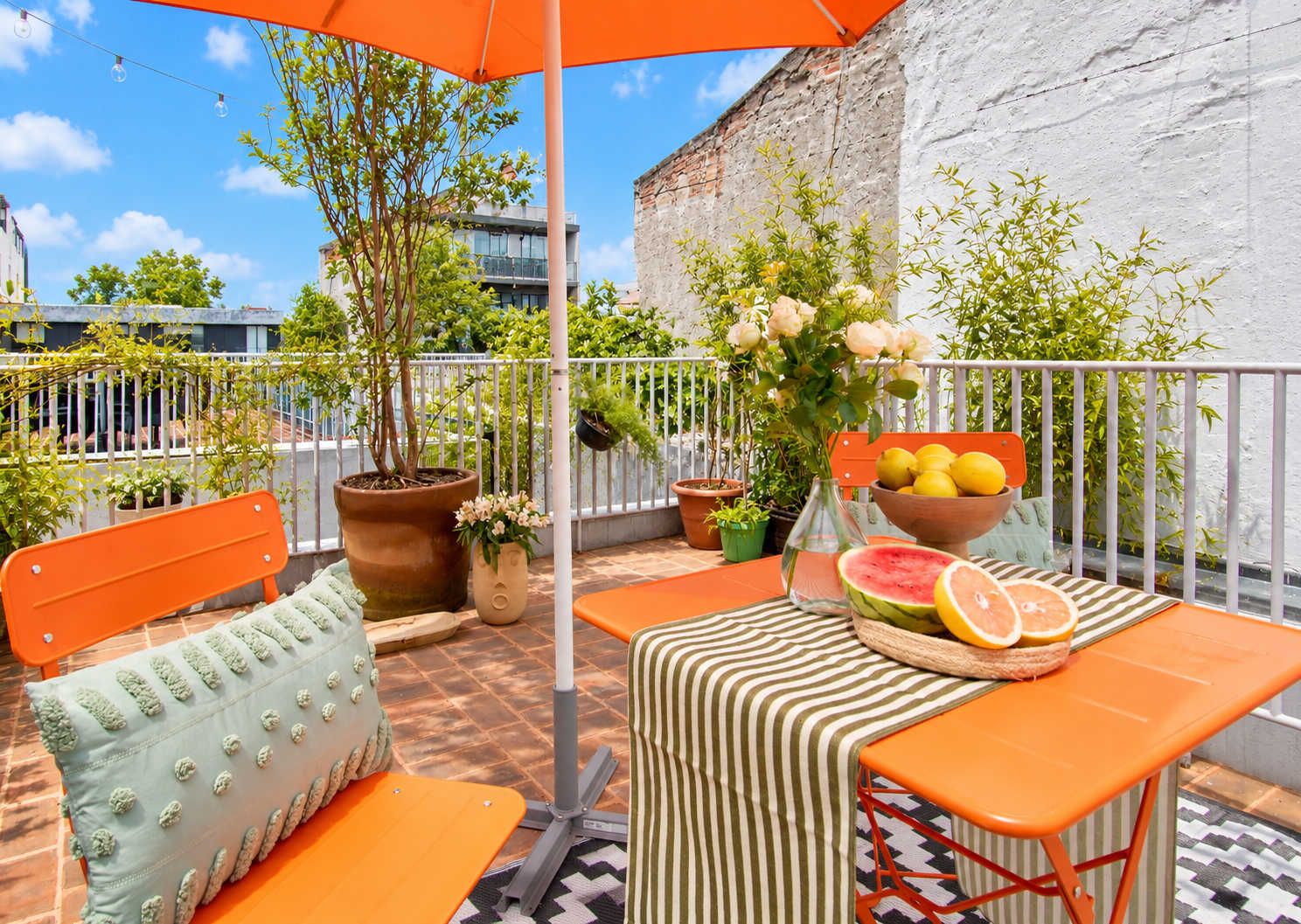 An outdoor seating area with a table, chairs, and a potted plant.
