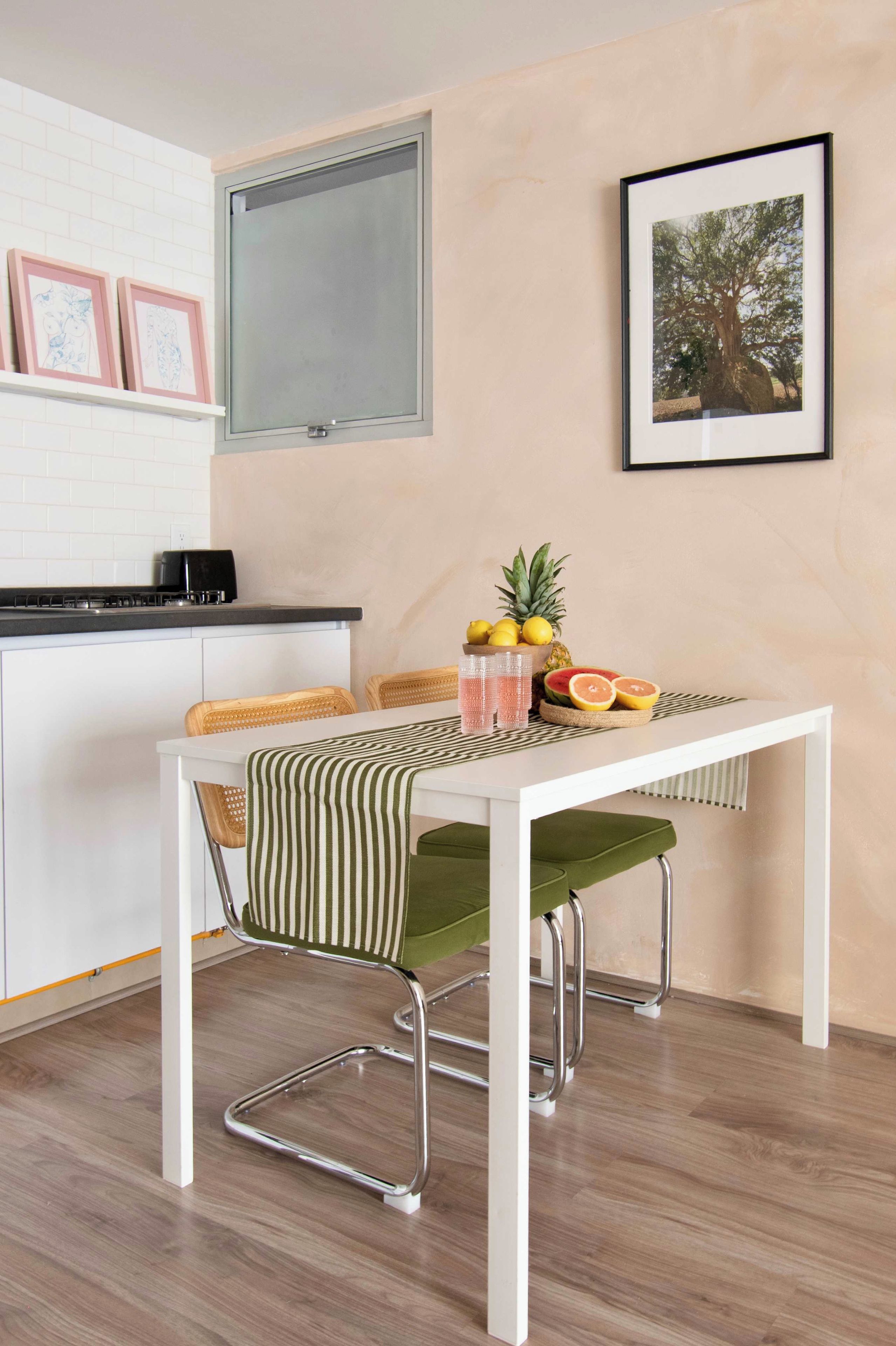 A modern kitchen with a white countertop, a black coffee machine, and a window above the sink.