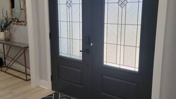 A double door with glass panels and a geometric patterned rug in front.