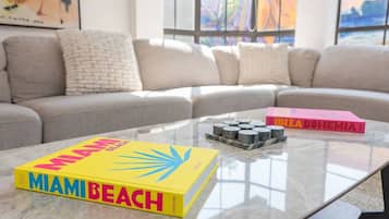 A living room with a sofa, a coffee table, and two books.