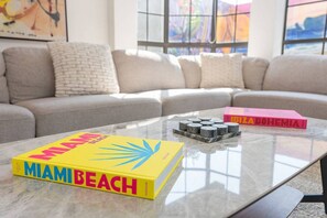 A living room with a sofa, a coffee table, and two books.