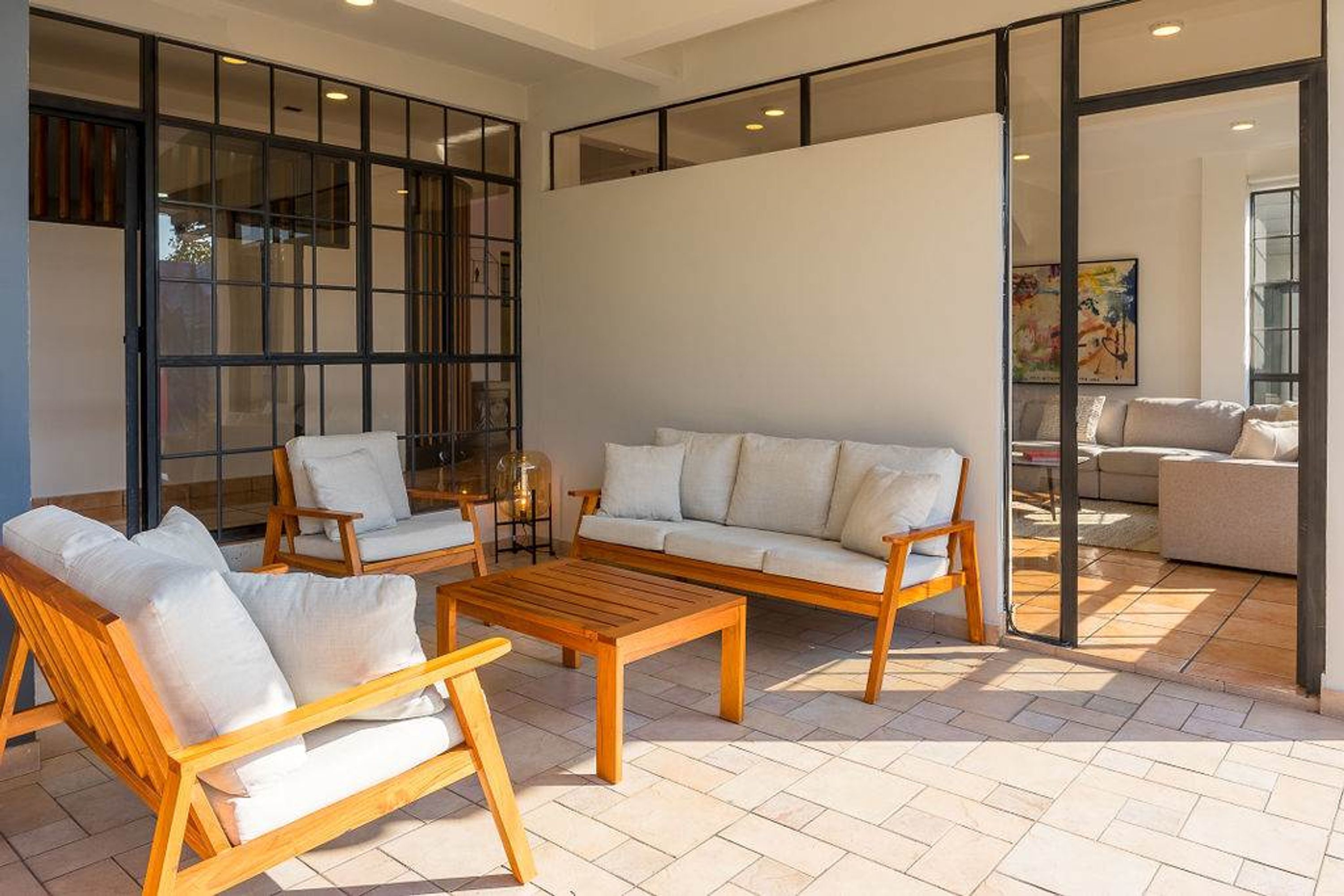 A spacious living area with a wooden coffee table, two sofas, and two armchairs.