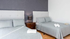 Ett hotellrum med två sängar, ett nattduksbord med en lampa och ett par handdukar på golvet.