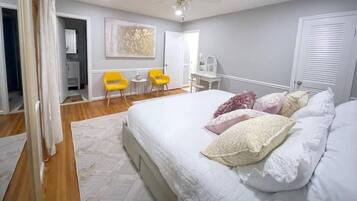 A bedroom with a bed, a ceiling fan, and a small table with chairs.