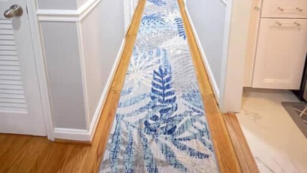 A narrow hallway with white walls, a patterned rug, and a kitchen area with cabinets and appliances. - Lux Family Xcape With Hottub Fireplace Deck BBQ (Silver Spring)