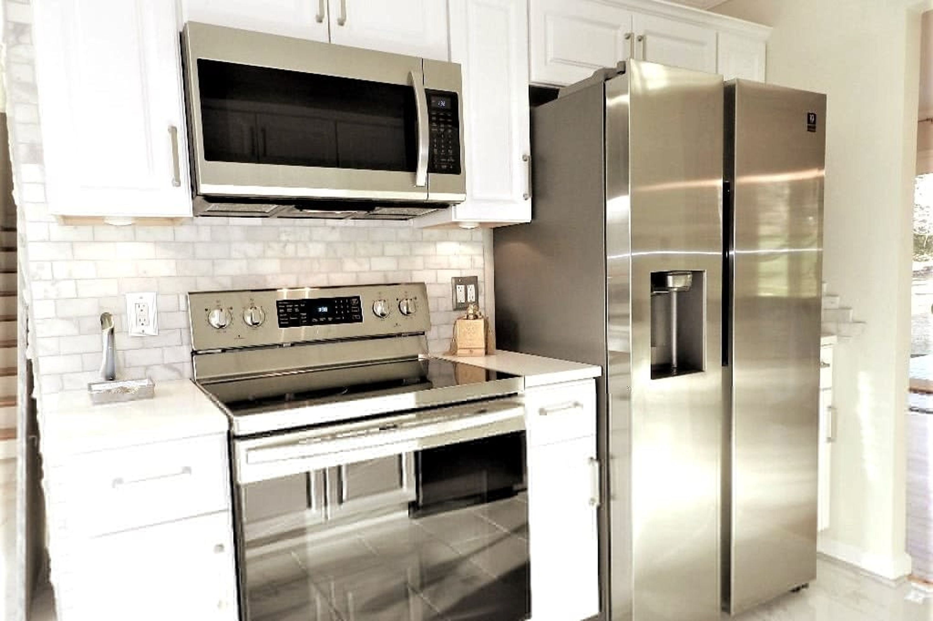 A kitchen with stainless steel appliances, including a microwave, oven, and refrigerator.