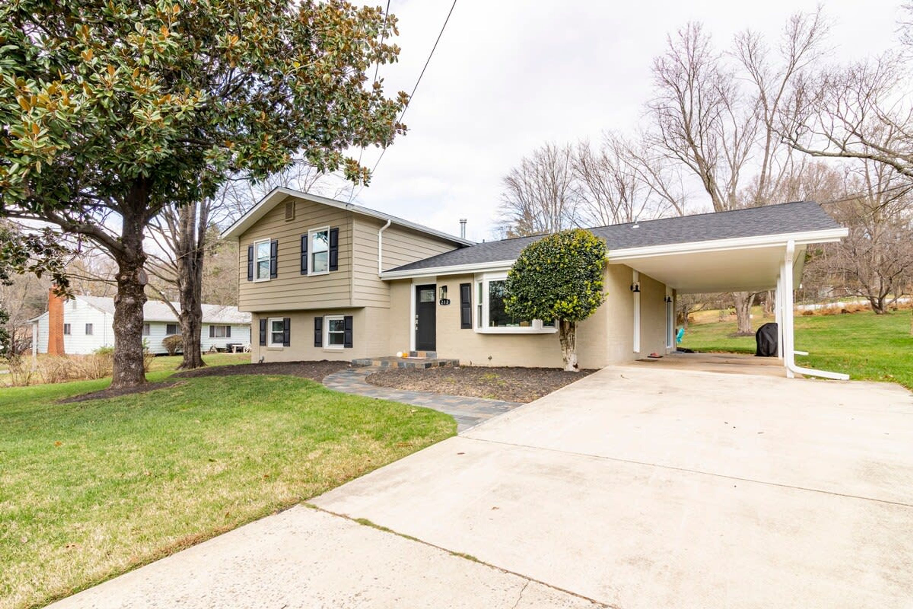 A two-story house with a covered garage and a well-maintained lawn.