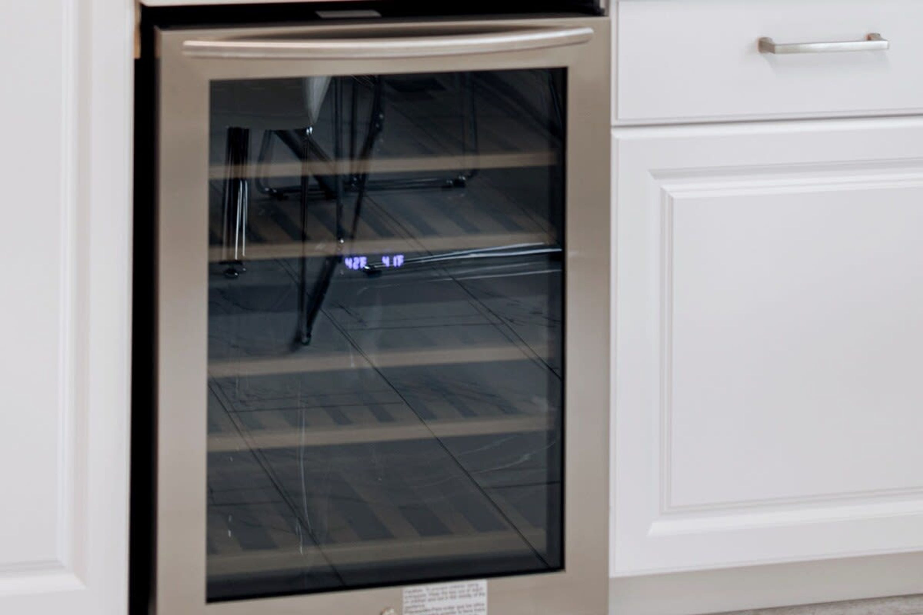A kitchen with a dishwasher, a white cabinet, and a stainless steel oven.