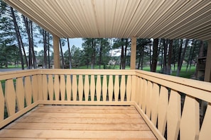 A wooden deck with a railing, surrounded by trees. - Innsbrook Vacation Townhome 23 (Ruidoso)