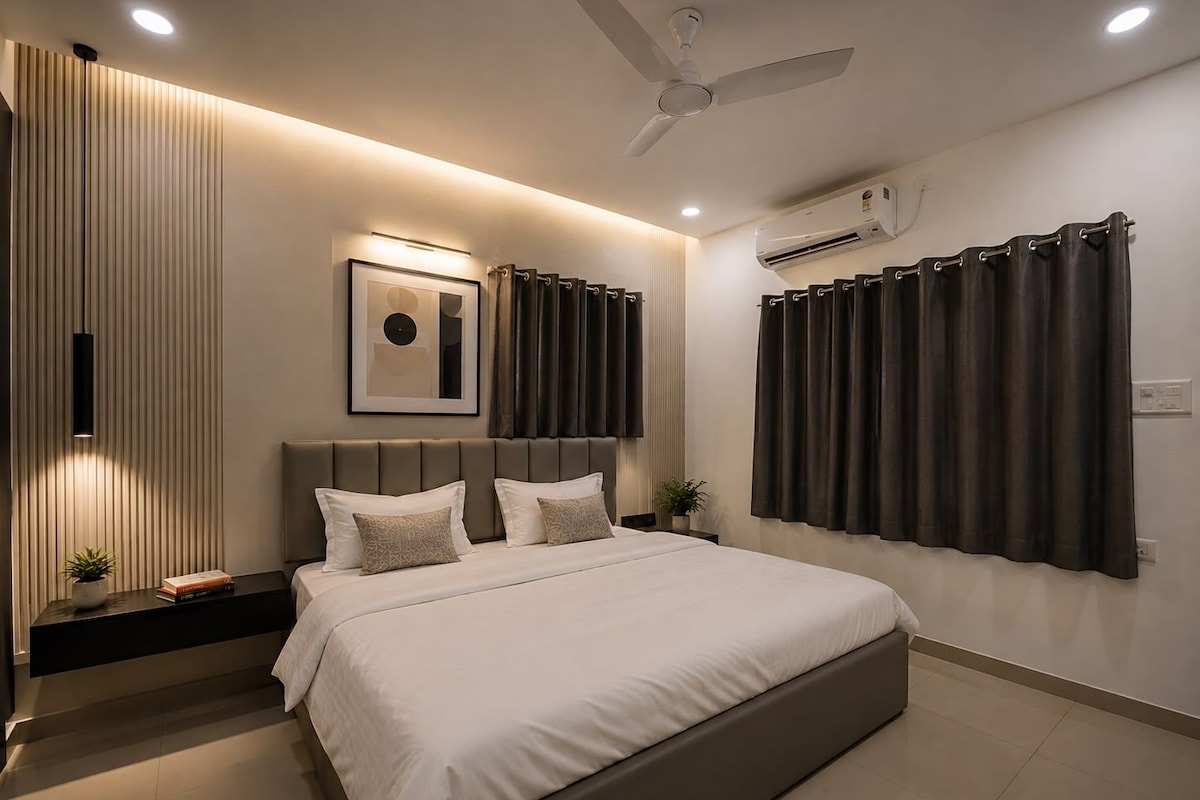 Un dormitorio moderno con cama, mesitas de noche, ventilador de techo y aire acondicionado.
