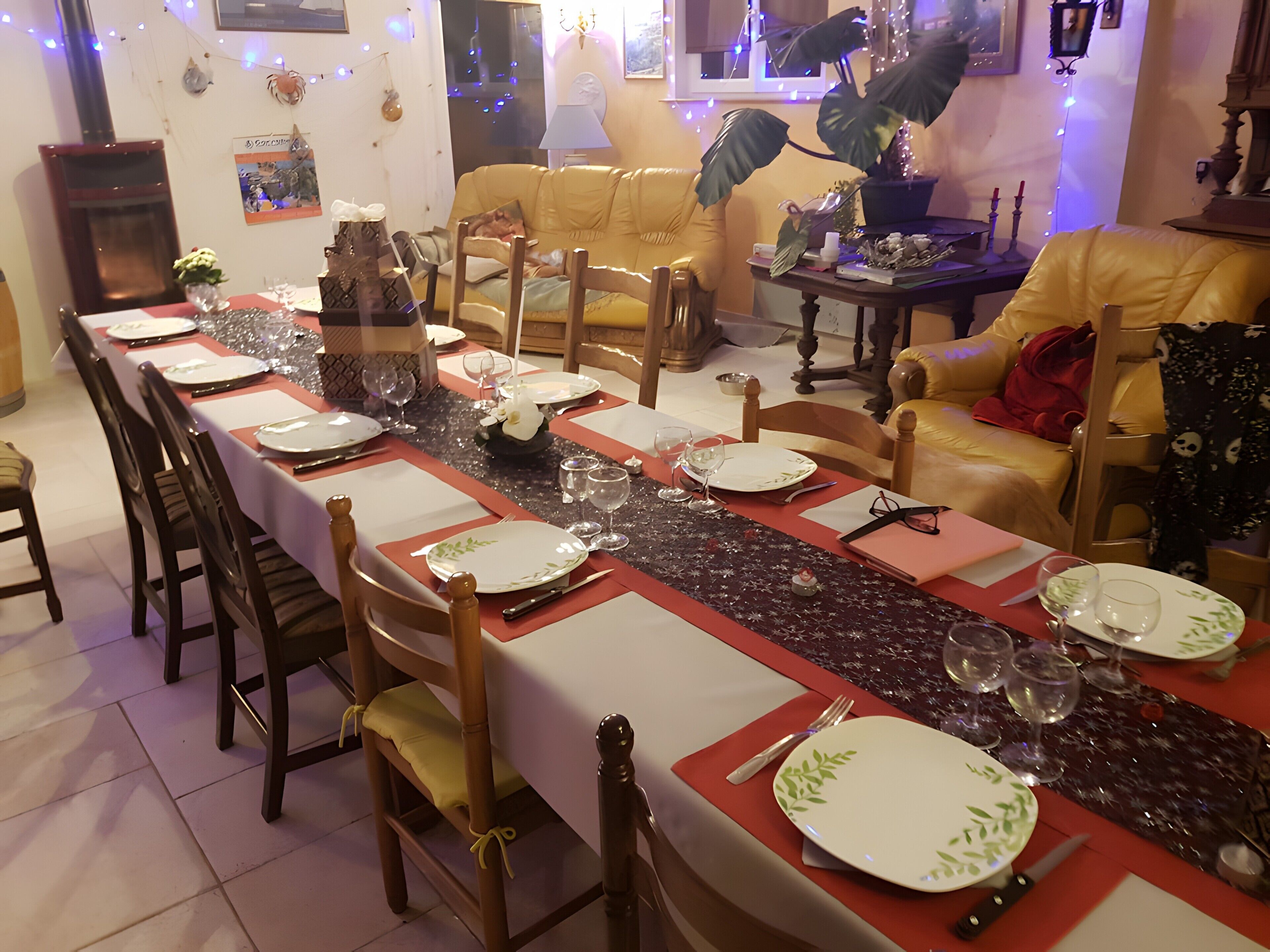 A dining area with a long table set for a meal, surrounded by chairs.