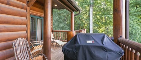 A wooden deck with a grill and outdoor seating.