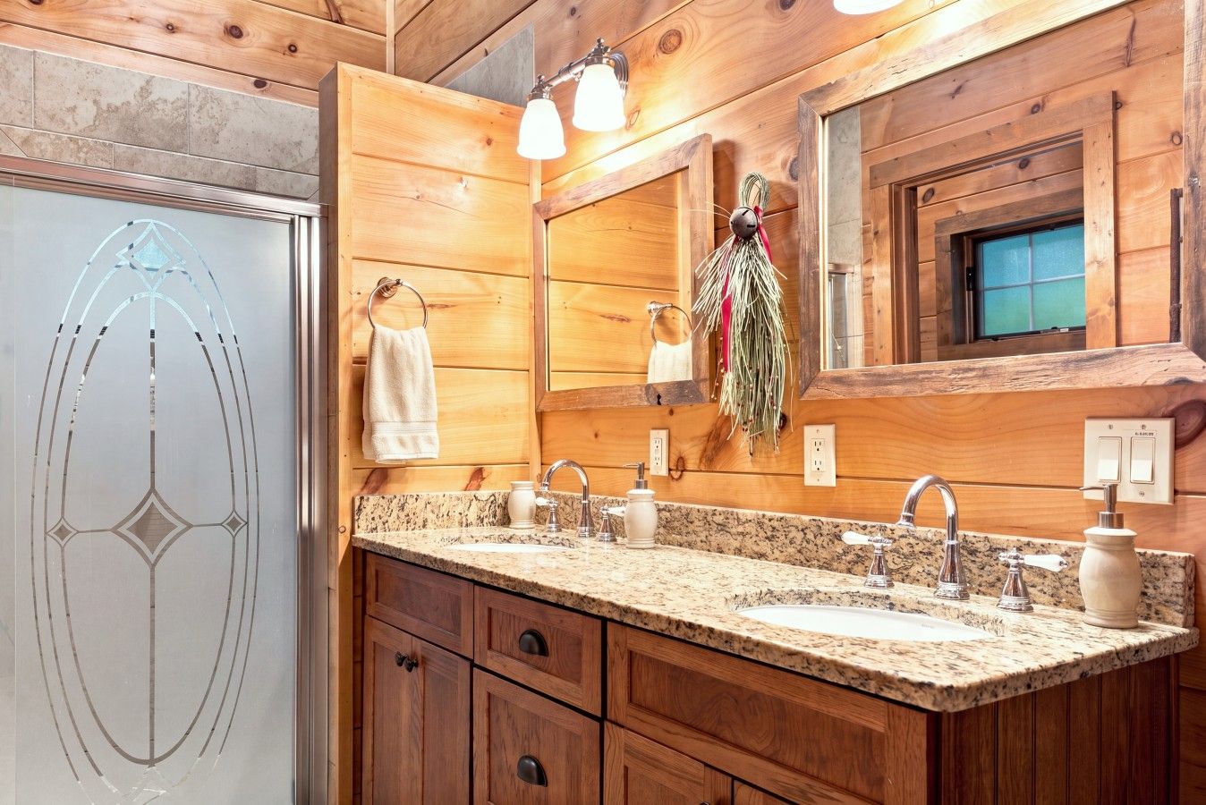 A wooden bathroom with two sinks, a mirror, and a towel rack.