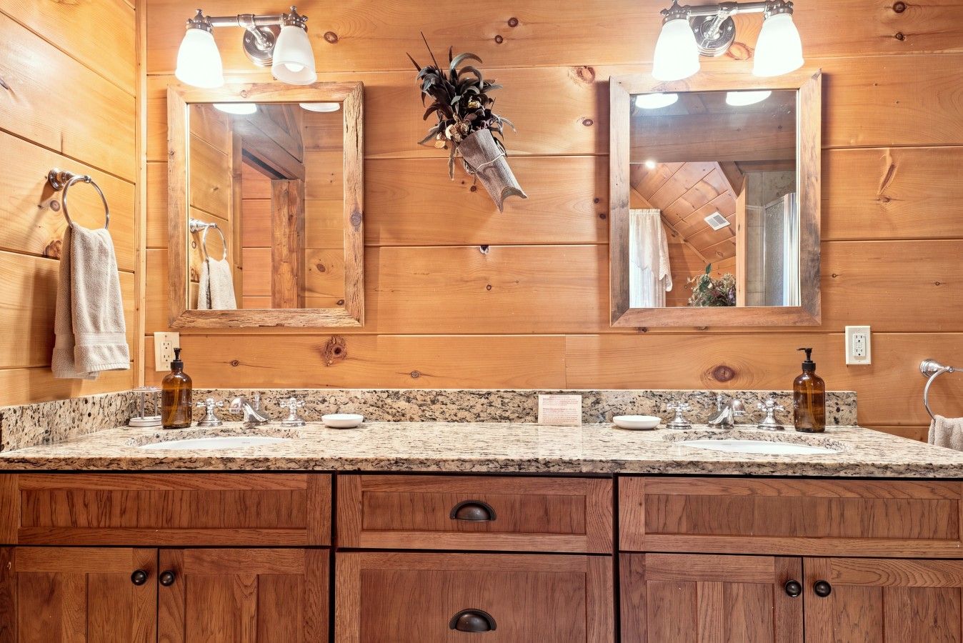 A wooden bathroom with two sinks, a mirror, and a towel rack.