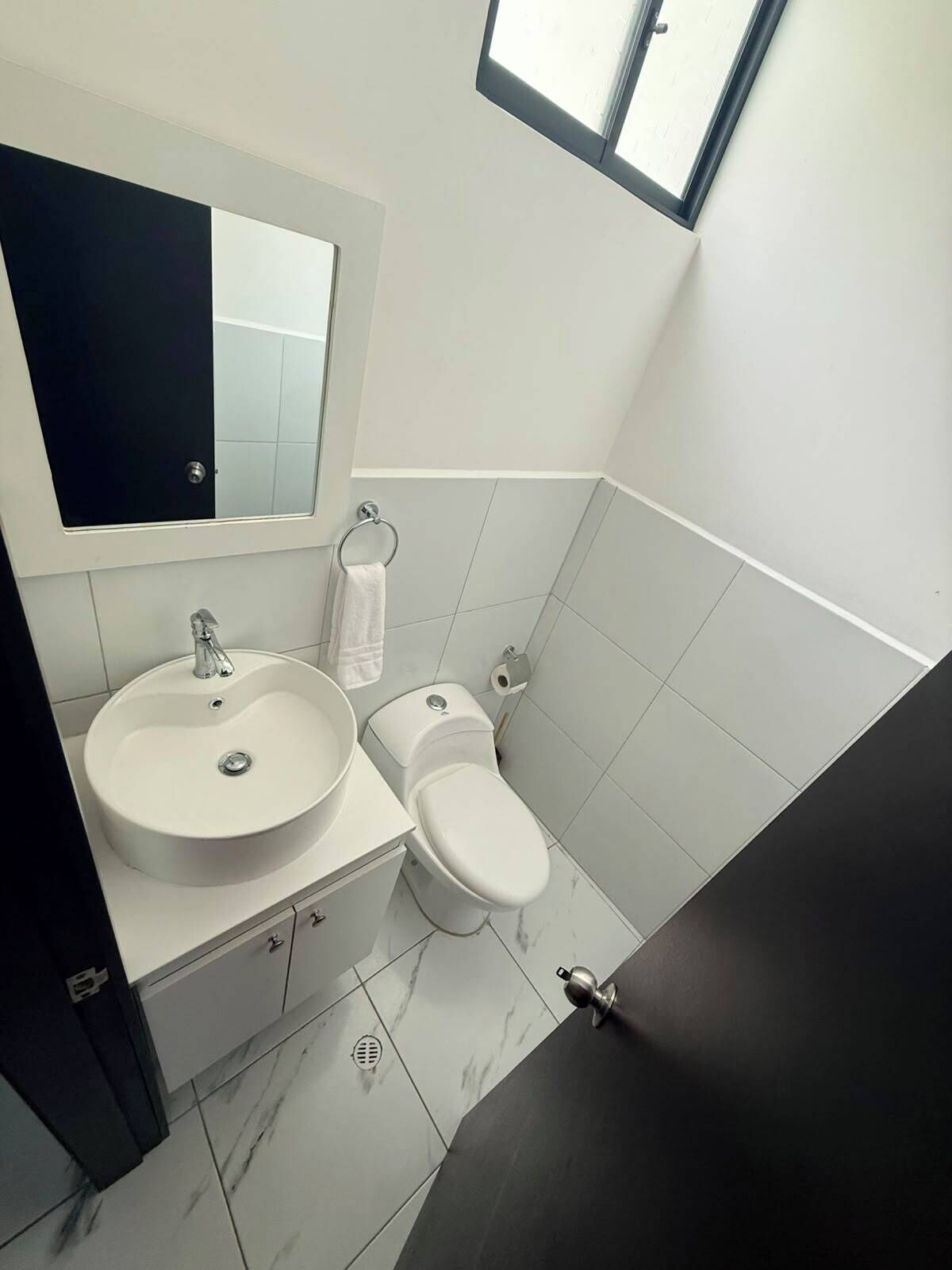 A bathroom with a white sink, a toilet, and a mirror above the sink.