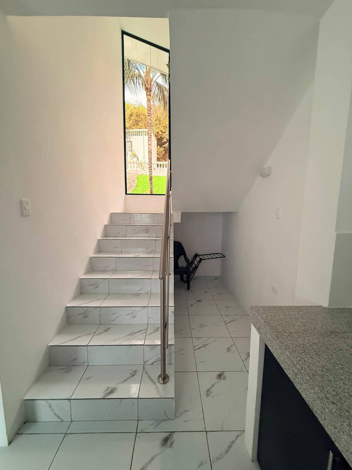 A staircase with marble steps leading to a landing.