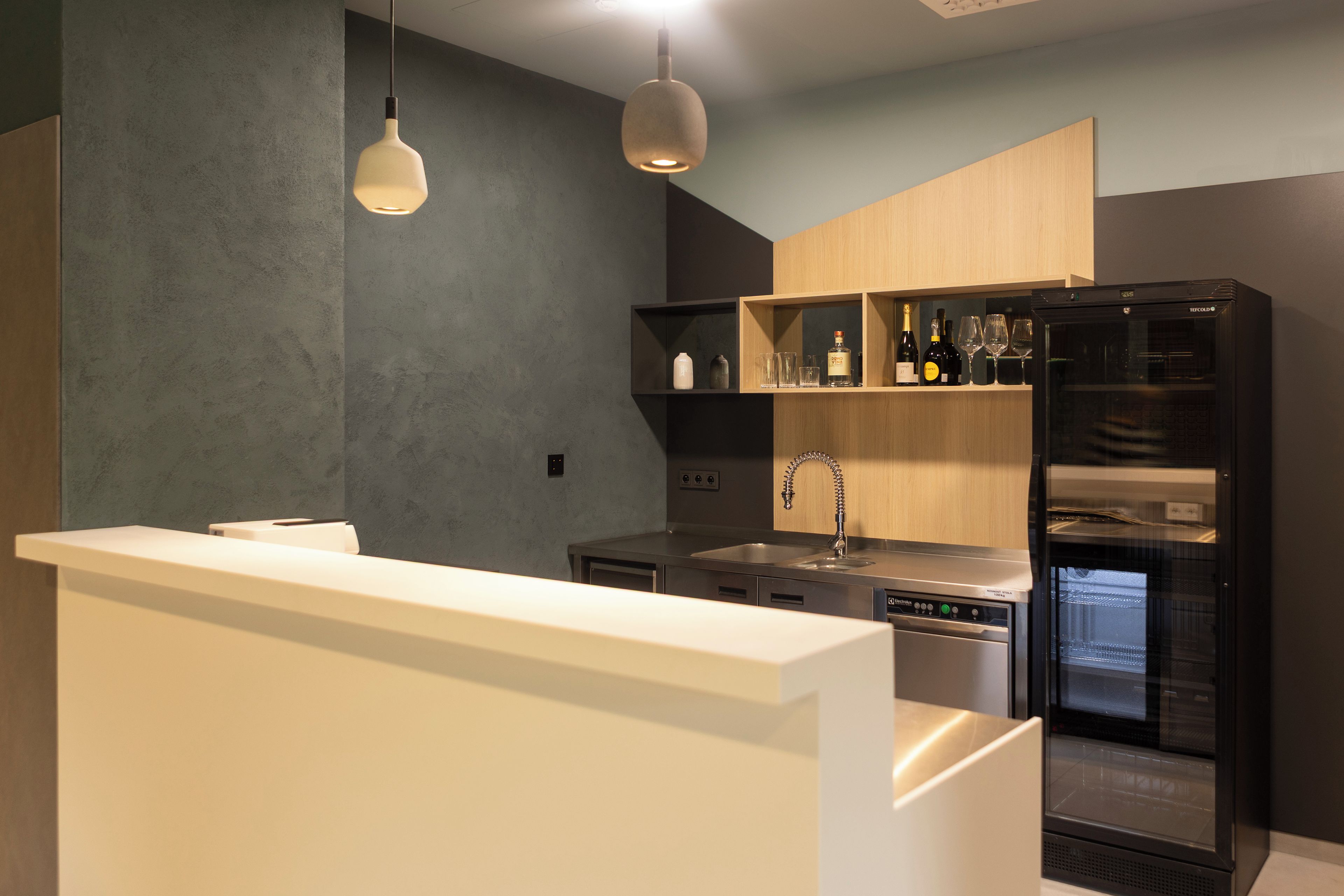 A modern kitchen with a built-in refrigerator, a sink, and a wine rack.