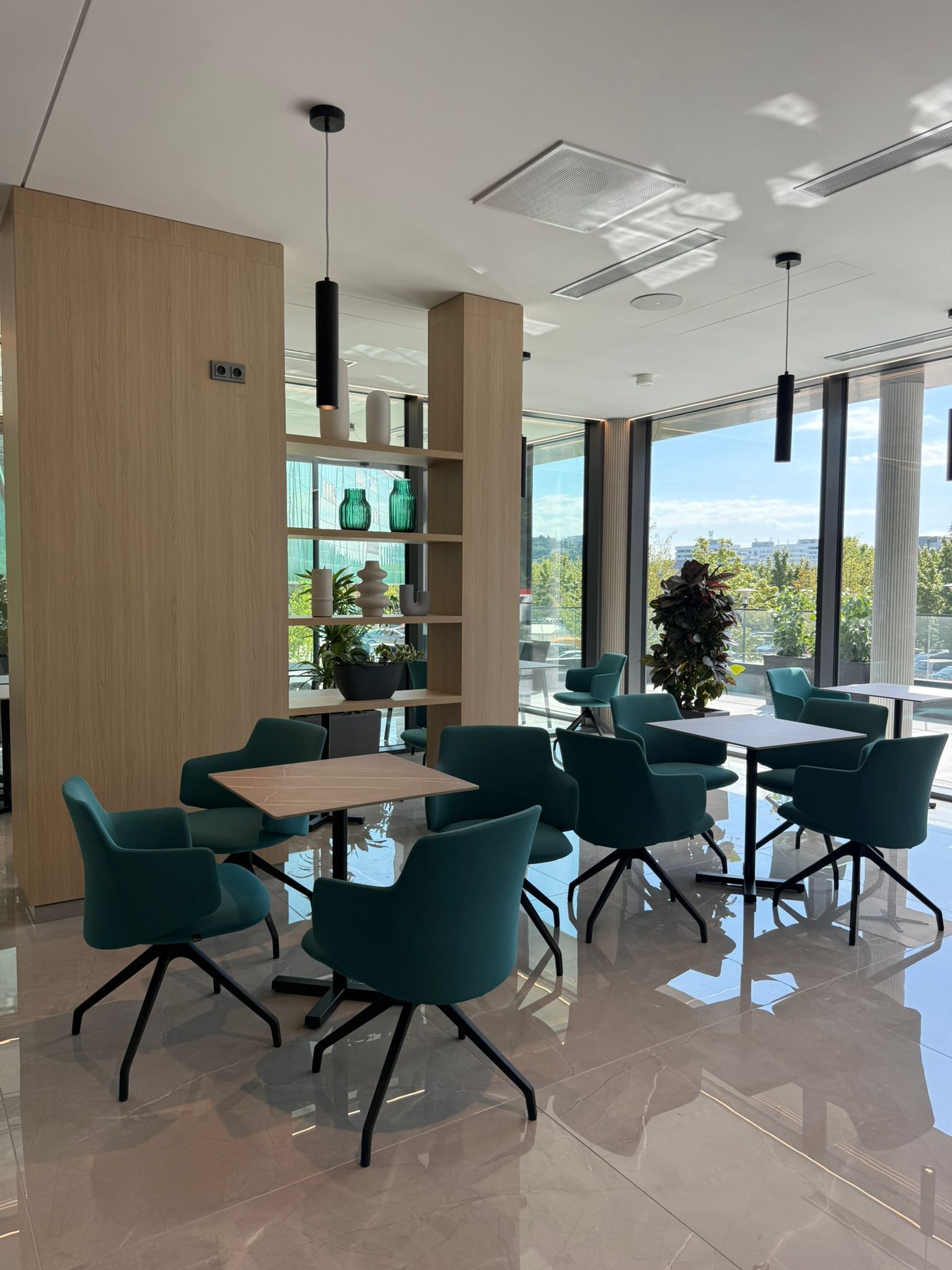 Een modern interieur met een glazen tafel en stoelen, een houten kolom en uitzicht door grote ramen.